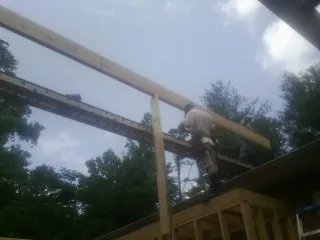 Carpenter setting a ridge beam over a new addition frame — Ice Dam Removal by Roofing Brothers in Tarzan