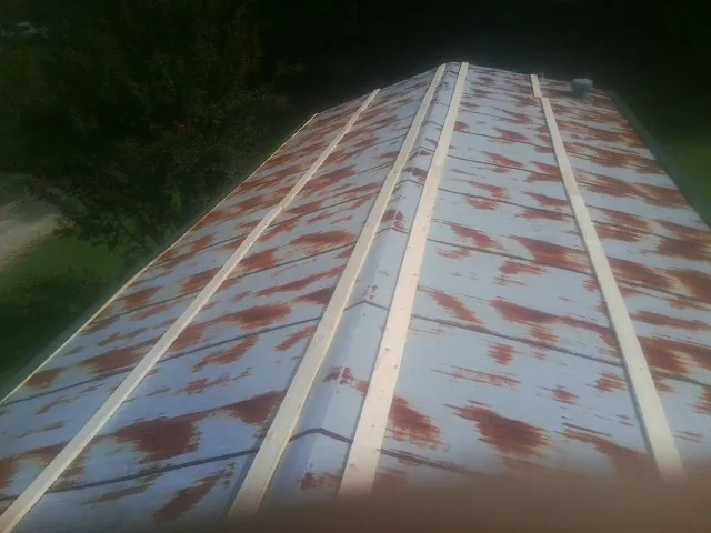 Rusted metal roof panels with new wood purlins before replacement — Storm Damage Roof Repair in Tarzan by Roofing Brothers